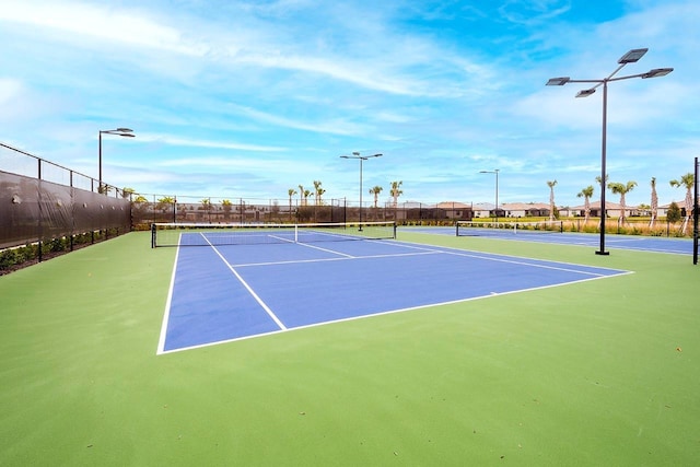 view of tennis court featuring fence