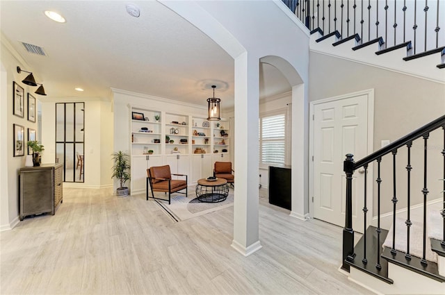 5709 Sunflower Cir, Sarasota, FL 34238 - entrance foyer featuring arched walkways, wood finished floors, stairs, and visible vents