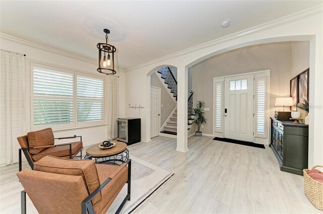 5709 Sunflower Cir, Sarasota, FL 34238 - foyer featuring baseboards, arched walkways, stairway, ornamental molding, and light wood-type flooring