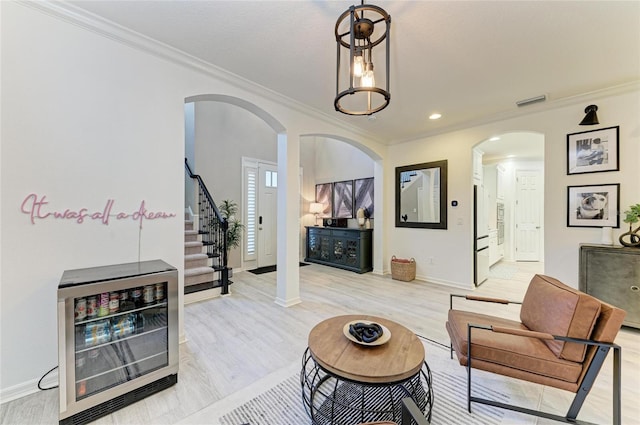5709 Sunflower Cir, Sarasota, FL 34238 - living area with light wood finished floors, ornamental molding, arched walkways, and stairs