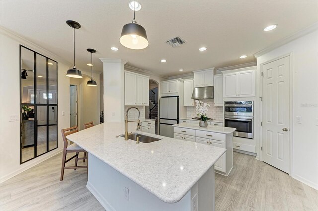 5709 Sunflower Cir, Sarasota, FL 34238 - kitchen featuring visible vents, a center island, stainless steel appliances, under cabinet range hood, and a sink