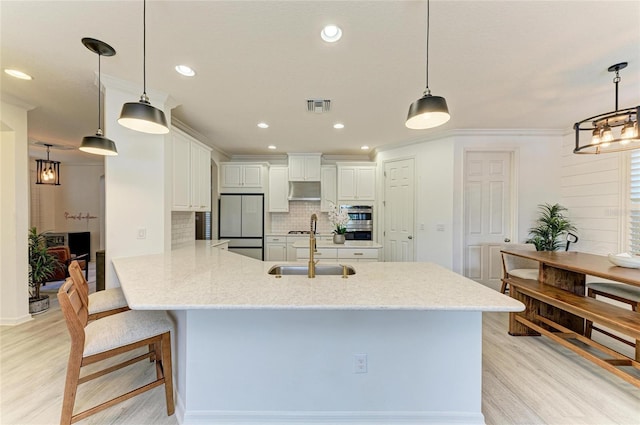 5709 Sunflower Cir, Sarasota, FL 34238 - kitchen with refrigerator, a peninsula, a sink, visible vents, and light wood-style floors