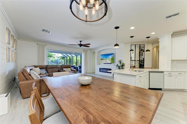 5709 Sunflower Cir, Sarasota, FL 34238 - dining area with light wood-style floors, visible vents, arched walkways, and a glass covered fireplace