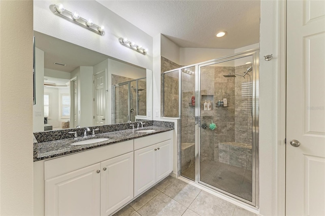 5709 Sunflower Cir, Sarasota, FL 34238 - full bathroom featuring a stall shower, tile patterned flooring, a textured ceiling, and a sink