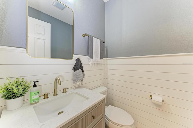 5709 Sunflower Cir, Sarasota, FL 34238 - half bath featuring visible vents, a wainscoted wall, vanity, and toilet
