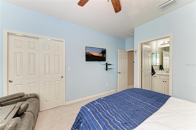 5709 Sunflower Cir, Sarasota, FL 34238 - bedroom featuring a textured ceiling, connected bathroom, carpet flooring, visible vents, and baseboards
