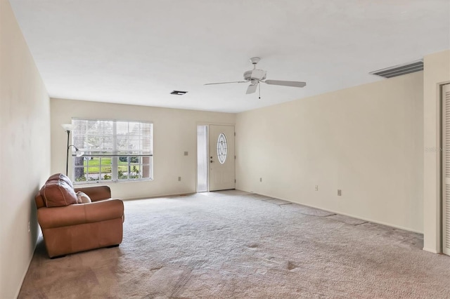 sitting room with a ceiling fan, carpet, and visible vents