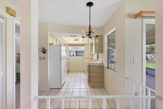 kitchen with visible vents, an inviting chandelier, freestanding refrigerator, light tile patterned flooring, and a sink