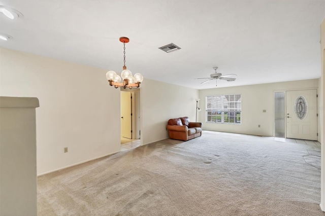 unfurnished room with ceiling fan with notable chandelier, visible vents, and light colored carpet