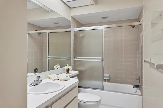 full bathroom featuring toilet, shower / bath combination with glass door, and vanity