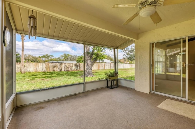 unfurnished sunroom with ceiling fan and beam ceiling