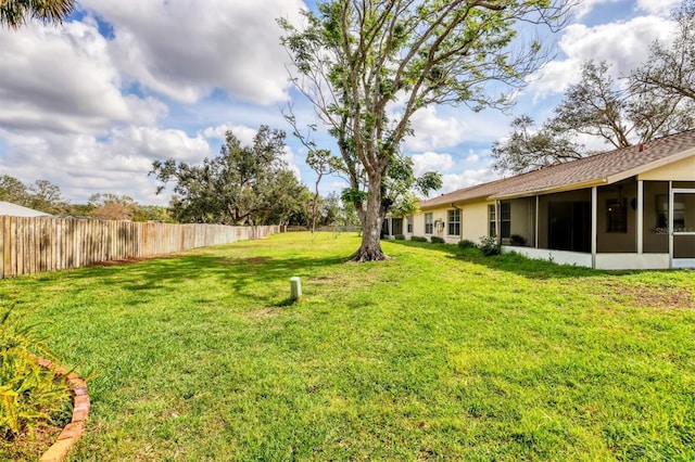 view of yard featuring fence and a sunroom