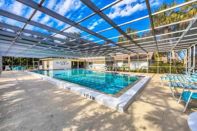 community pool with a patio and glass enclosure