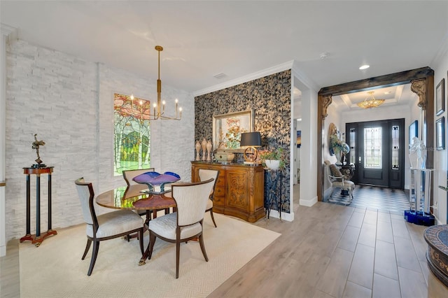 dining room with baseboards, ornamental molding, wood finished floors, and an inviting chandelier