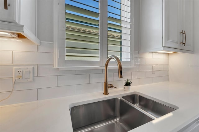 interior details featuring tasteful backsplash, light countertops, and a sink