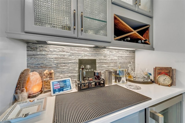 bar featuring tasteful backsplash and wine cooler