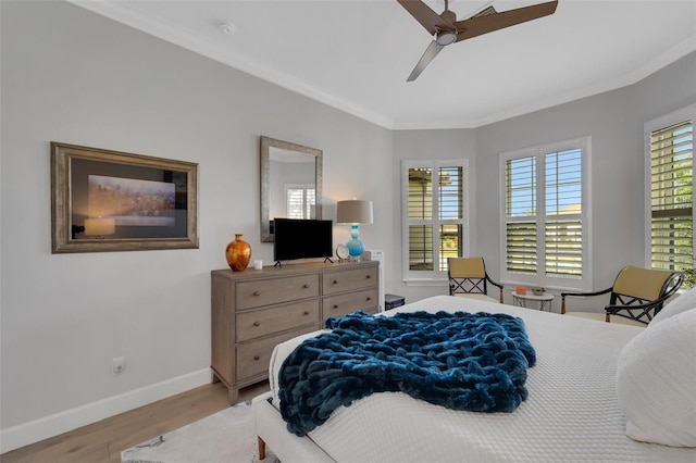 bedroom with ornamental molding, baseboards, multiple windows, and light wood finished floors