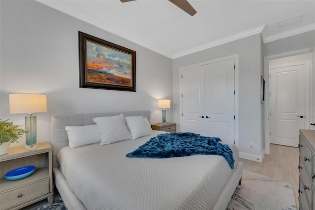 bedroom with light wood-style flooring, a ceiling fan, baseboards, ornamental molding, and a closet