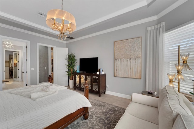 bedroom with light wood-style floors, a raised ceiling, visible vents, and a notable chandelier