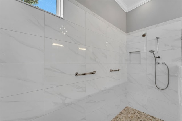 full bath featuring ornamental molding and tiled shower