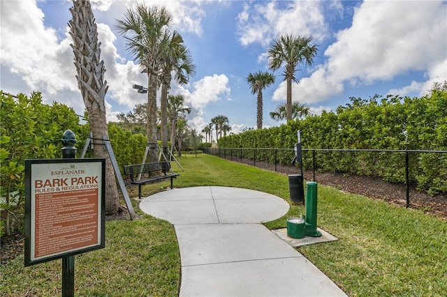 surrounding community with fence and a yard