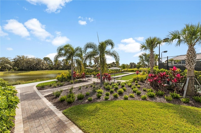 view of property's community with a yard and a water view