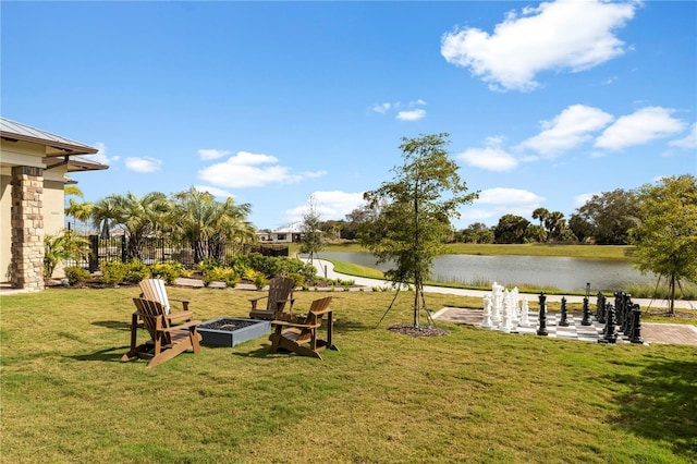 view of yard with an outdoor fire pit and a water view