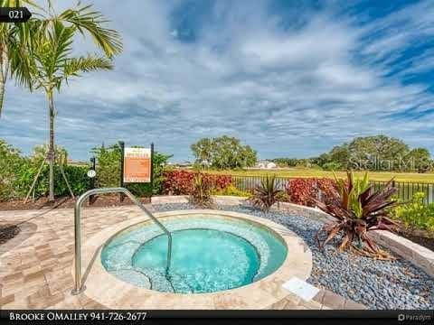 view of pool with a community hot tub and fence