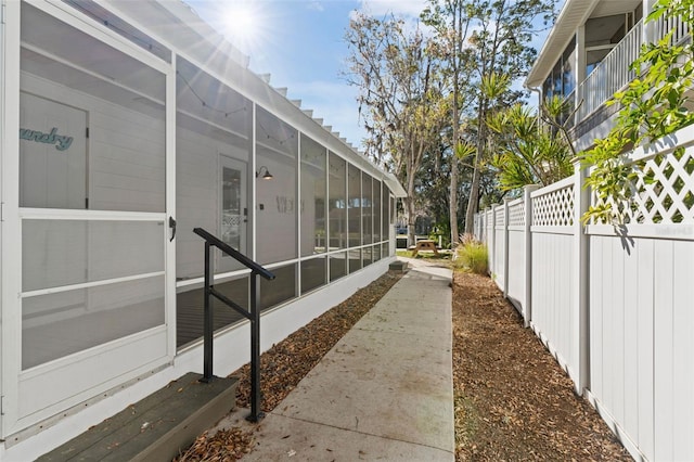 exterior space featuring a sunroom and fence