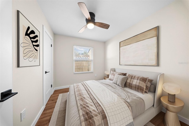 bedroom featuring ceiling fan, baseboards, and wood finished floors