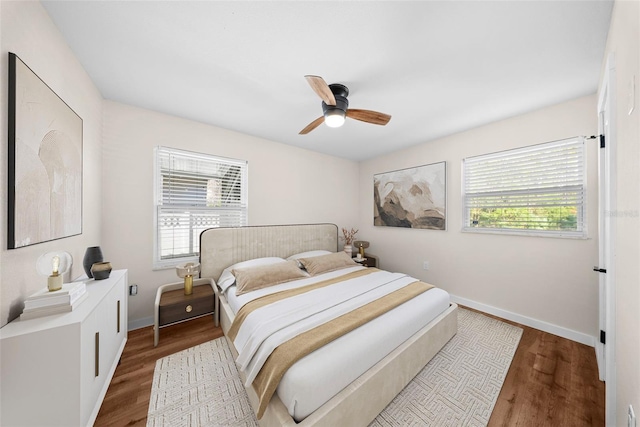 bedroom with a ceiling fan, baseboards, and wood finished floors