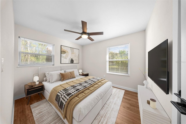 bedroom with ceiling fan, baseboards, and wood finished floors