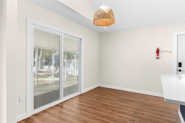 spare room featuring baseboards and wood finished floors