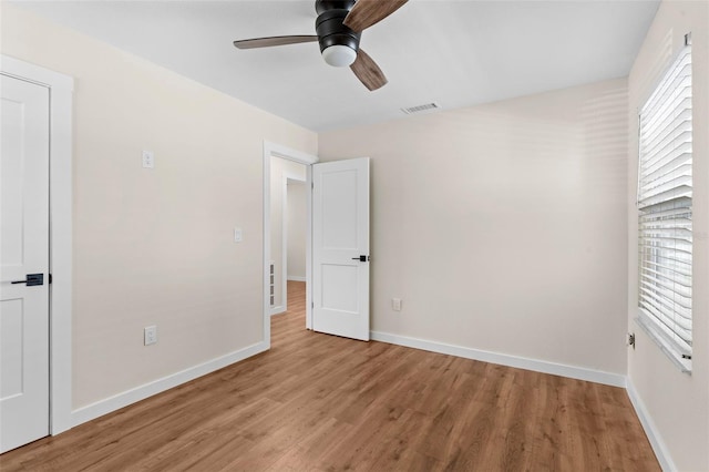 unfurnished bedroom with light wood-type flooring, baseboards, multiple windows, and visible vents