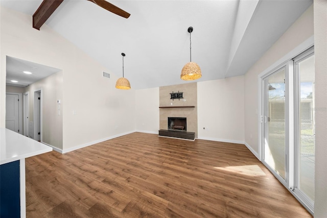 unfurnished living room with a large fireplace, baseboards, wood finished floors, beamed ceiling, and high vaulted ceiling