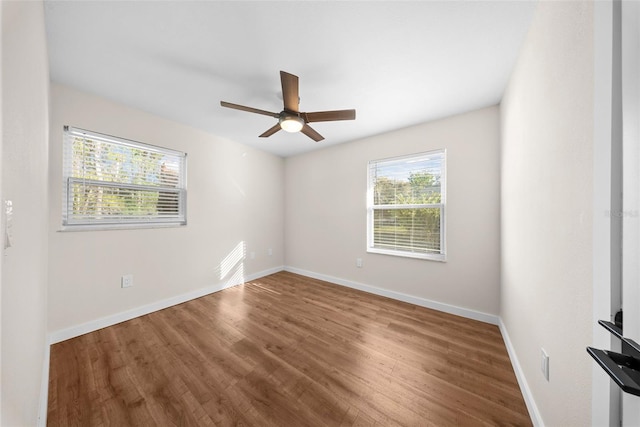 spare room with ceiling fan, wood finished floors, and baseboards