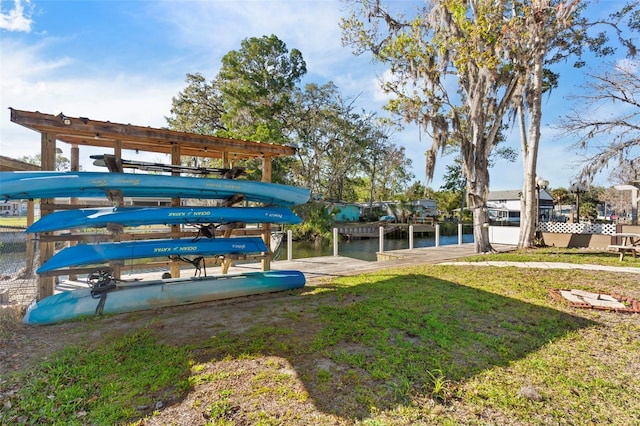 surrounding community with a lawn, a water view, and a dock