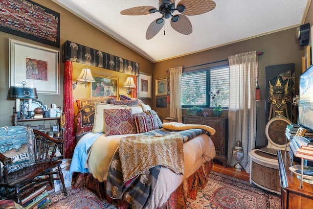 tiled bedroom with lofted ceiling, ceiling fan, and a textured ceiling