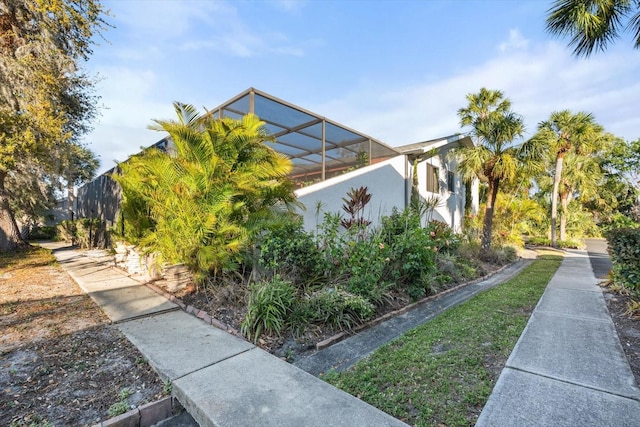 view of property exterior featuring glass enclosure