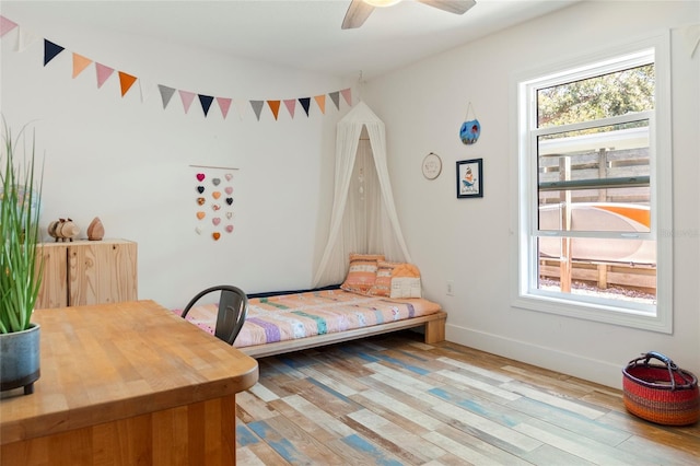 bedroom featuring light wood-style floors, baseboards, and a ceiling fan