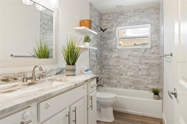 bathroom featuring bathtub / shower combination, vanity, toilet, and wood finished floors