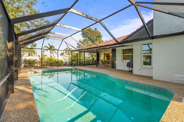 outdoor pool with a lanai, a patio area, and area for grilling