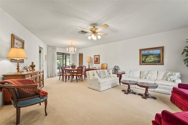 living room with light carpet, visible vents, a textured ceiling, and ceiling fan with notable chandelier