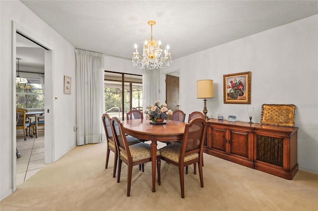 dining space featuring a chandelier, a textured ceiling, and light colored carpet