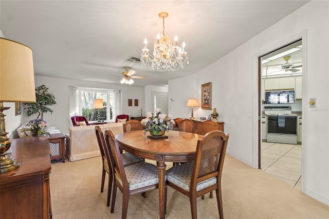 dining area with ceiling fan with notable chandelier, light tile patterned floors, visible vents, and light colored carpet