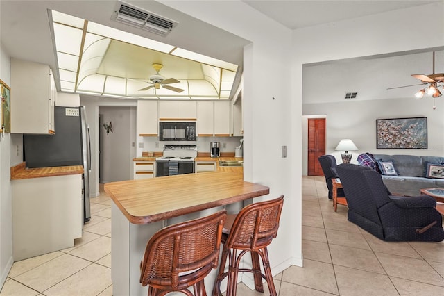 kitchen featuring visible vents, white electric stove, black microwave, and ceiling fan