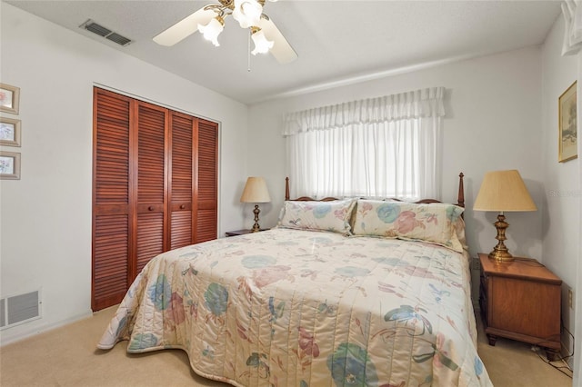 bedroom with a ceiling fan, visible vents, a closet, and carpet flooring