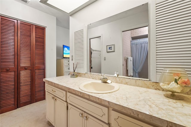 bathroom featuring a closet, a skylight, and vanity