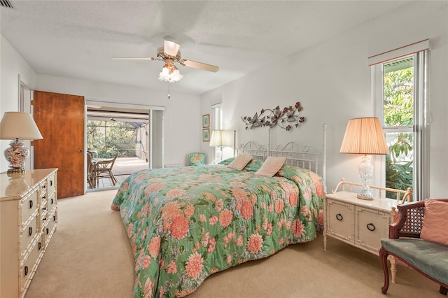 bedroom featuring light carpet, access to outside, multiple windows, and a ceiling fan