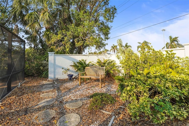 view of yard featuring a lanai and fence